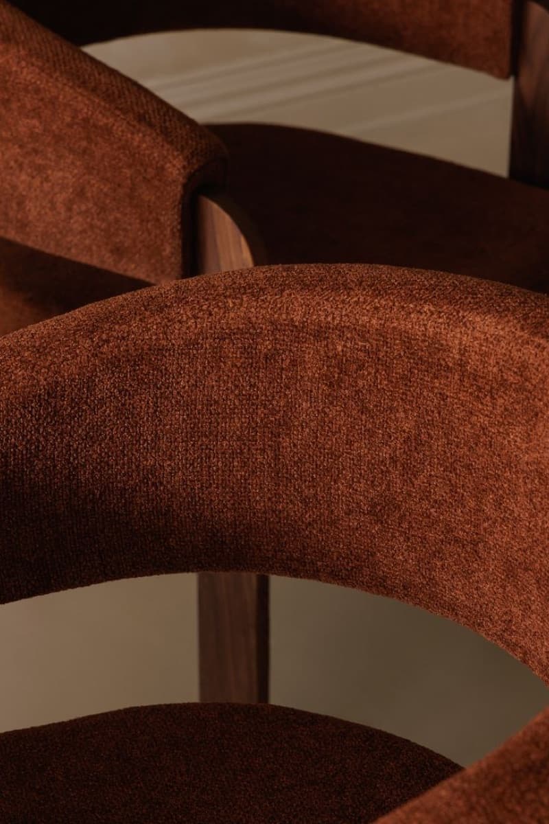 Detalle de una silla tapizada en bouclé terracota